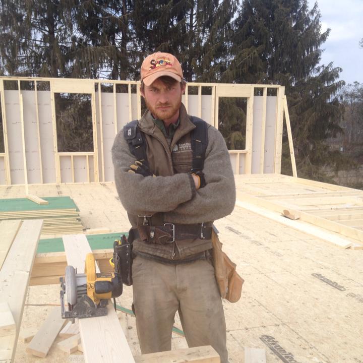 a man standing in front of a wood frame